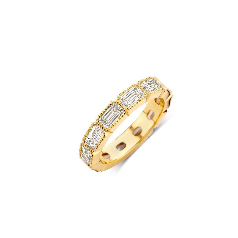 Golden ring surrounded by emerald cut diamonds set with miligrain.