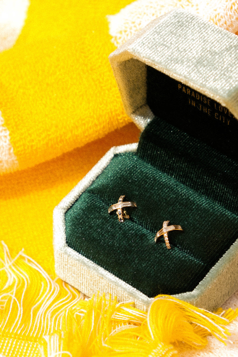 Gold earrings in a green jewelry box